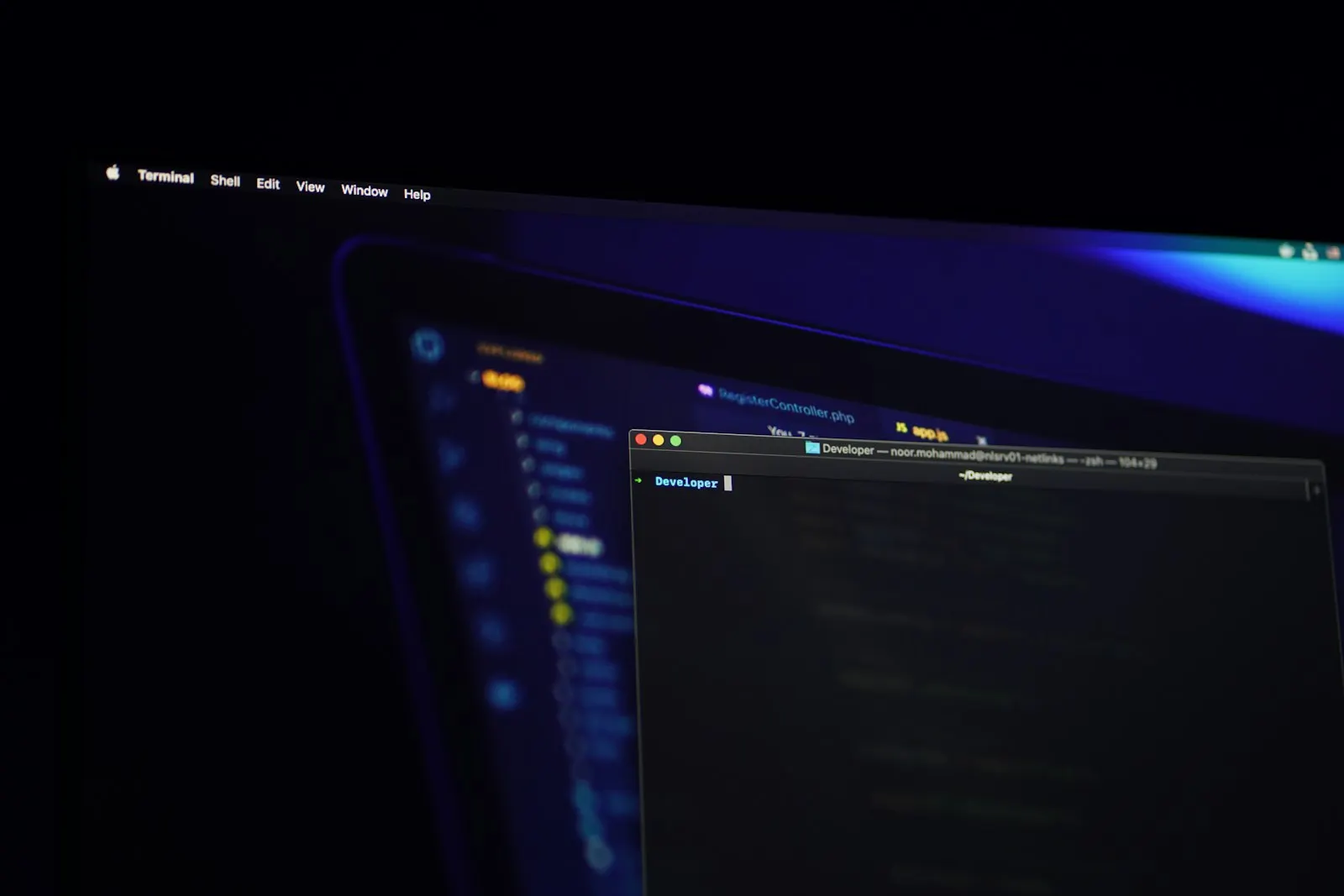 Monitor con código en pantalla sobre un escritorio a oscuras