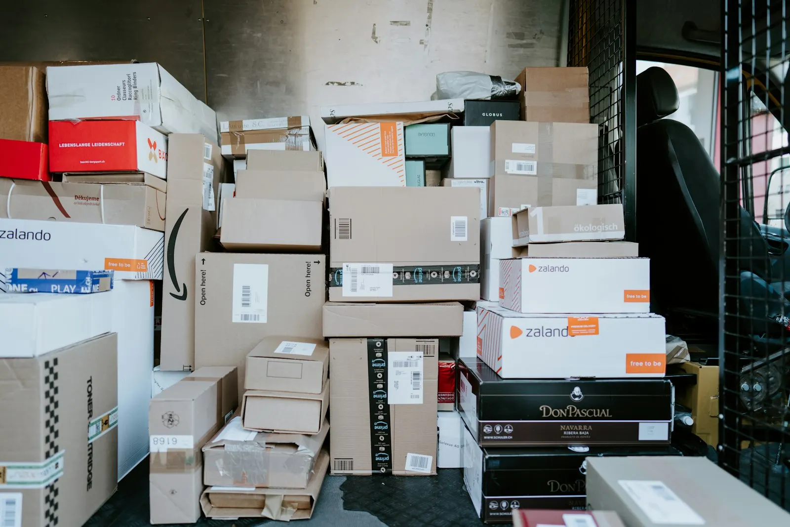 Cajas de cartón de pedidos apiladas en la parte trasera de una furgoneta de reparto